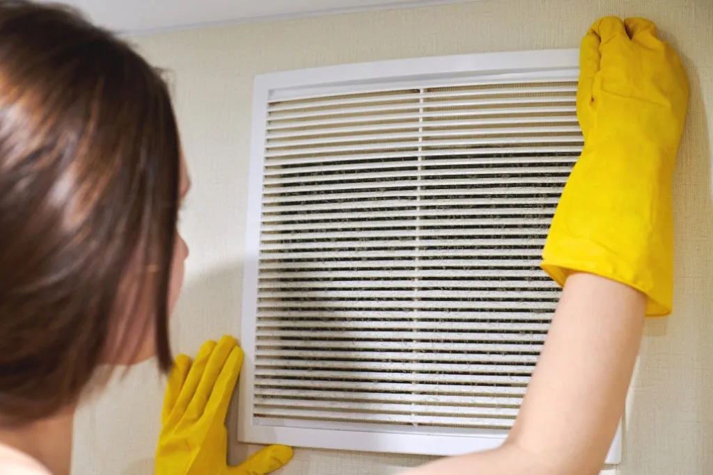 Čišćenje rešetke ventilacijskog otvora u zaštitnim rukavicama